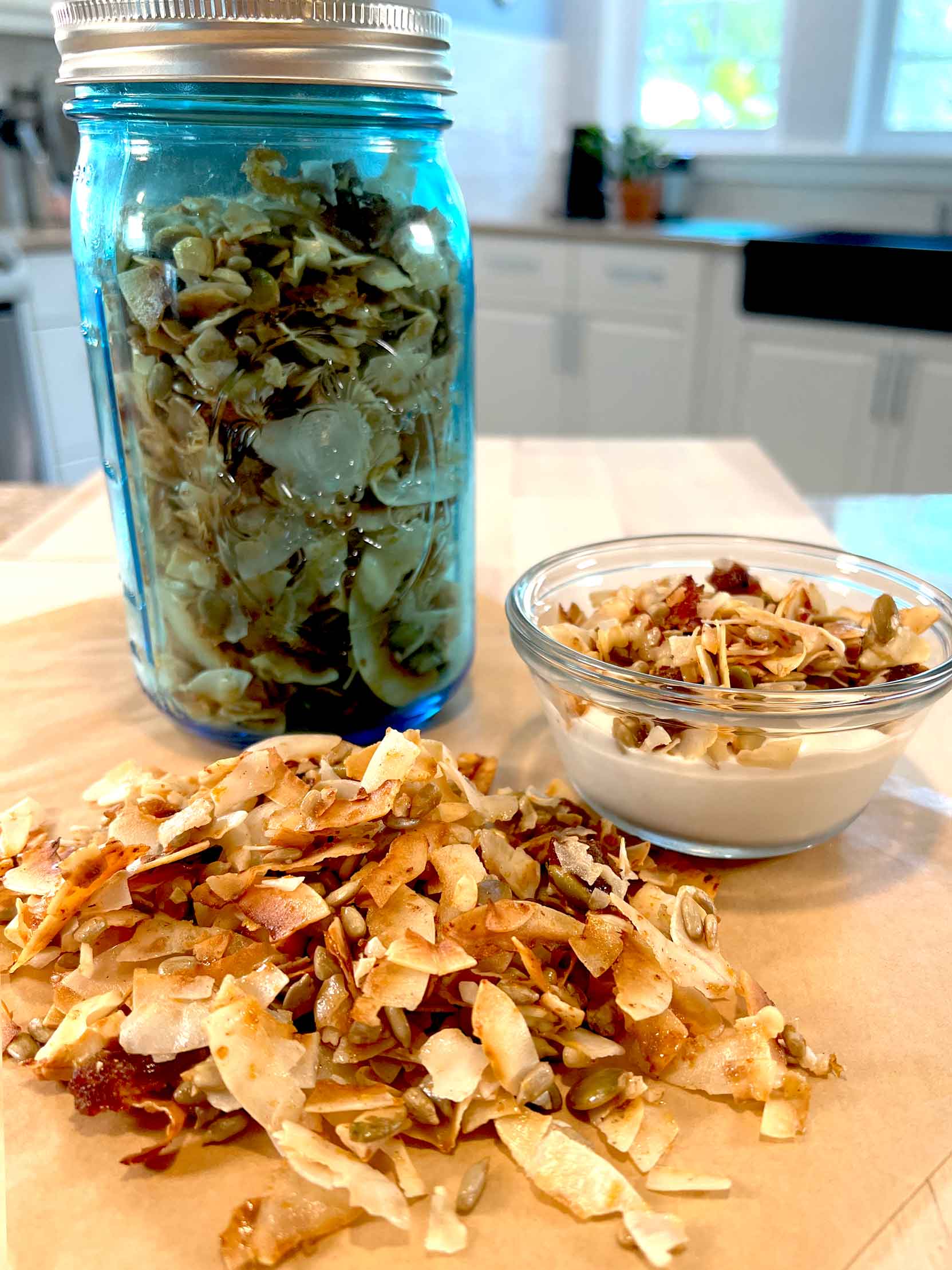 Honey Coconut Grain-Free Granola in a mason jar and topped on coconut yogurt cup