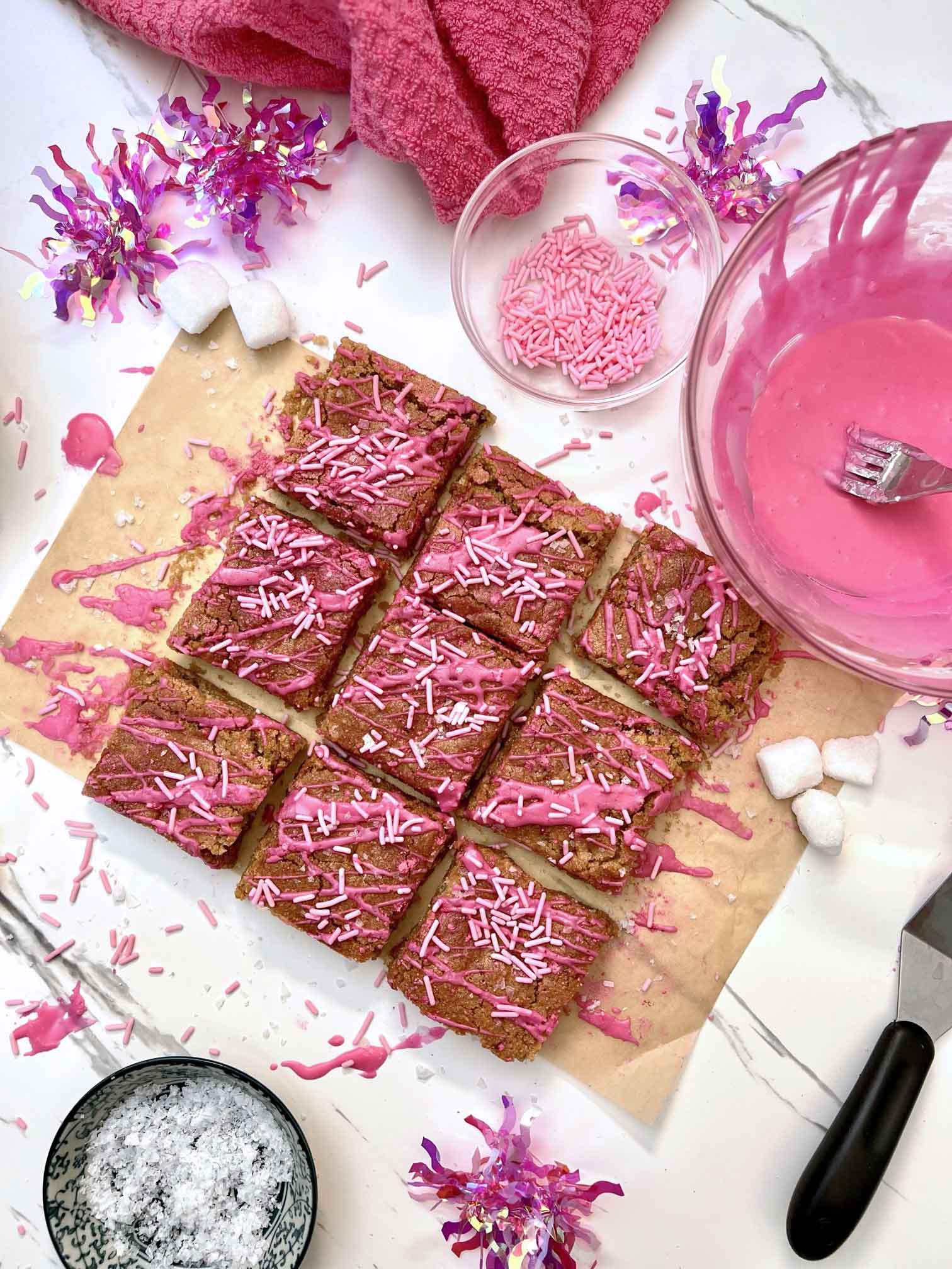 A  aerial view of Blondies decorated in Pink with icing and sprinkles. 