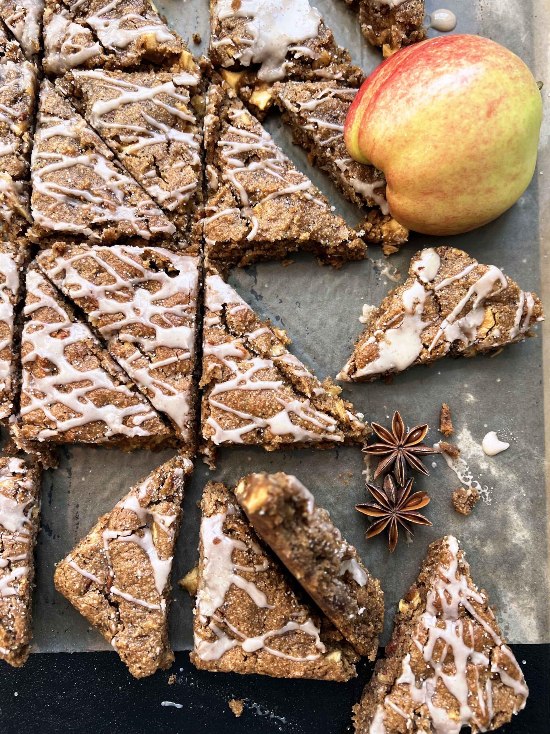 Apple Chai Cookie Bars arranged on parchment with apple and star anise.