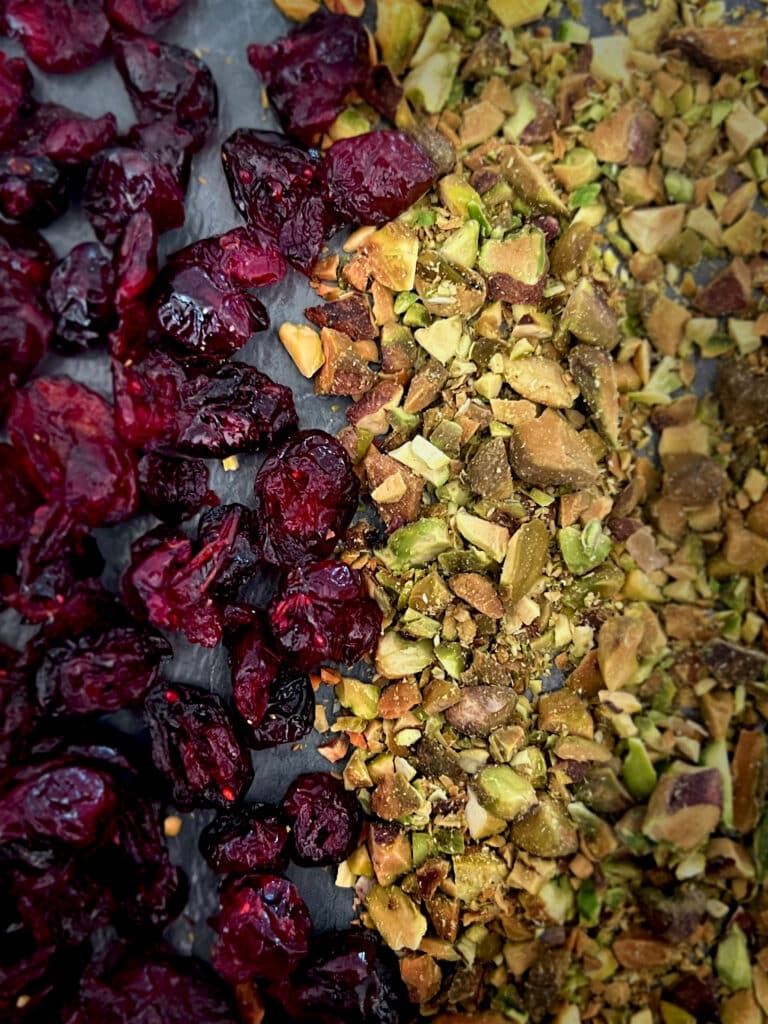 Image of Dried Cranberries on the left and chopped Pistachios on the right. 